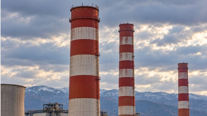 Εικόνα ΤΝ με κλειστά καταστήματα σε άδειο δρόμο και λιγνιτικές εγκαταστάσεις στο βάθος, σε ορεινό τοπίο.